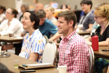 Attendees at a desk in a session