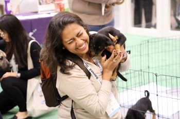 Person smiling laughing holding puppy