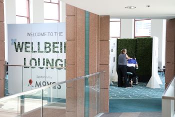 Wellbeing Lounge sign and person getting massage in background