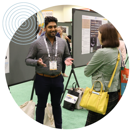 Presenter talking to attendee in front of posters