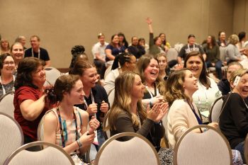 Technicians applauding and laughing in audience